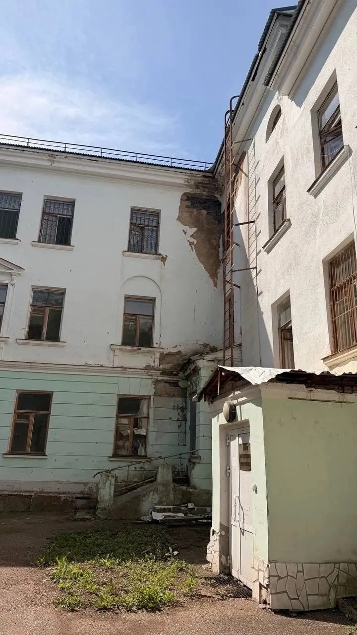 В здании СМЗ-поликлиники наблюдается серьёзное изношение — облупившиеся стены, трещины и отслаивающиеся покрытия. Пациенты обеспокоены безопасностью и качеством условий приёма.